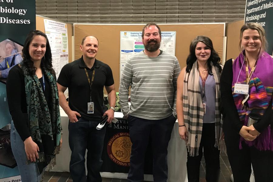 Group of researchers standing in front of a display.