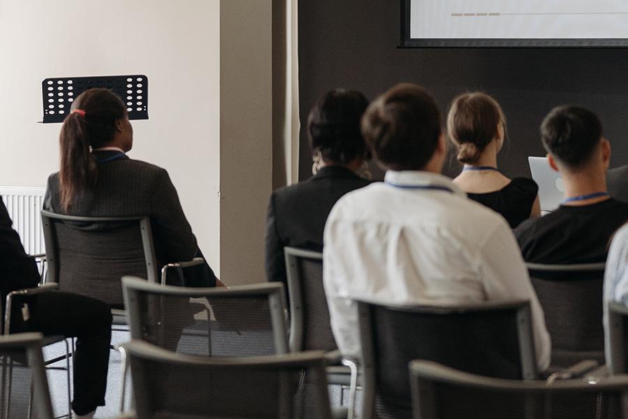 Diverse group of people sitting in front of a projector screen