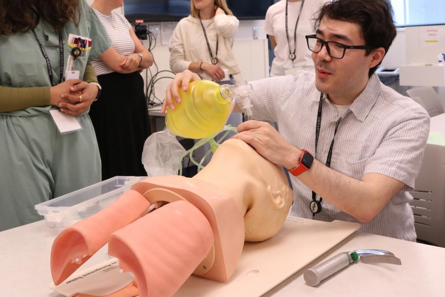 A medicial professional intubates a simulation mannequin.