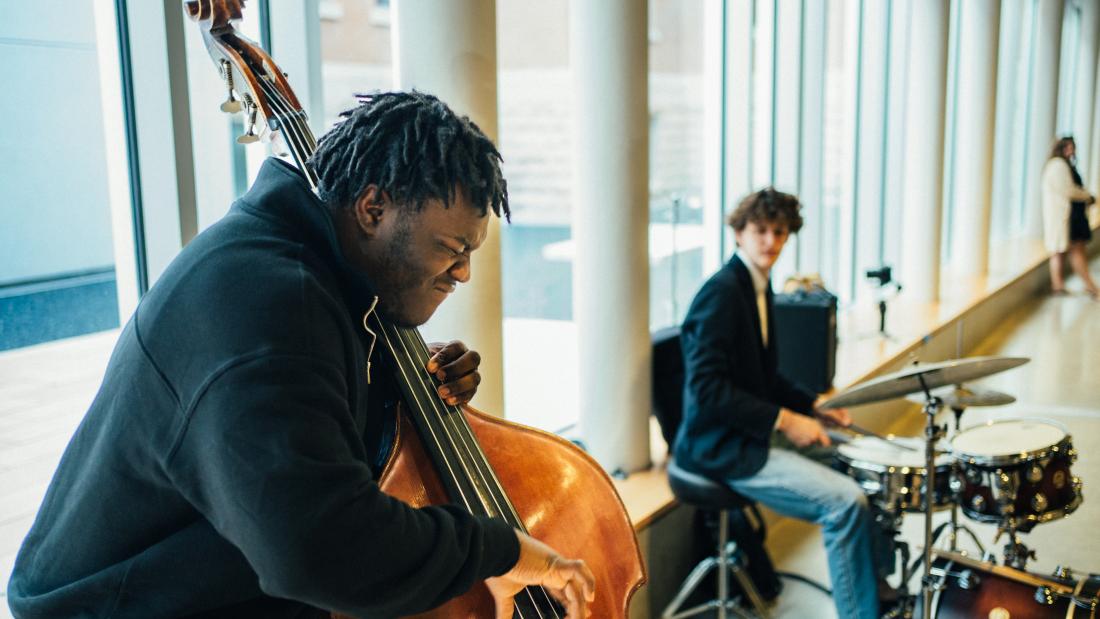man playing a double bass and man playing drums