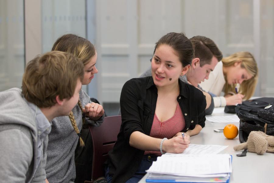 Students talking and studying together in the music library.