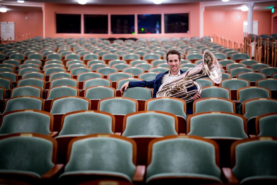 Tuba instructor Jarrett McCourt sitting in an auditorium