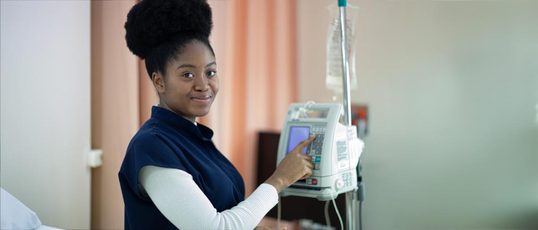 Nursing student adjusts an IV.