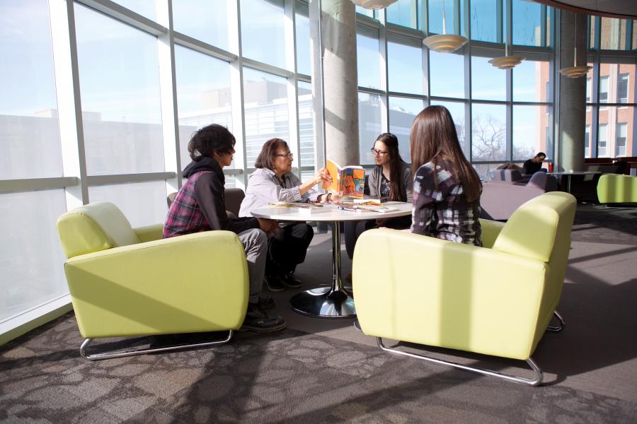 students sitting around a table in library