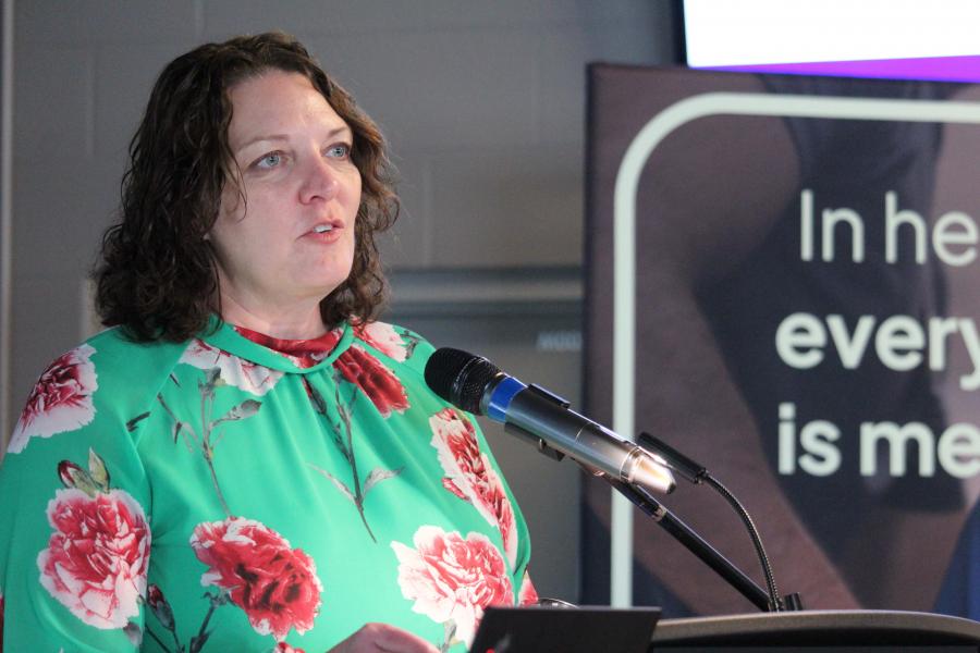 Nicole Harder speaking at a podium.