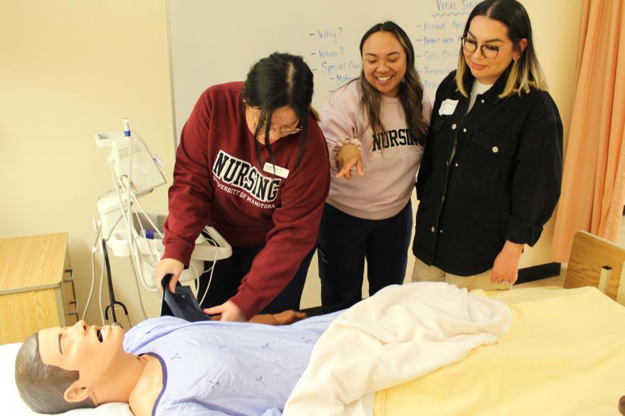 A group of nursing students working on a simulation patient in the skills lab.