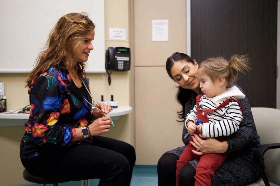 A doctor speaks to a mother and a child.