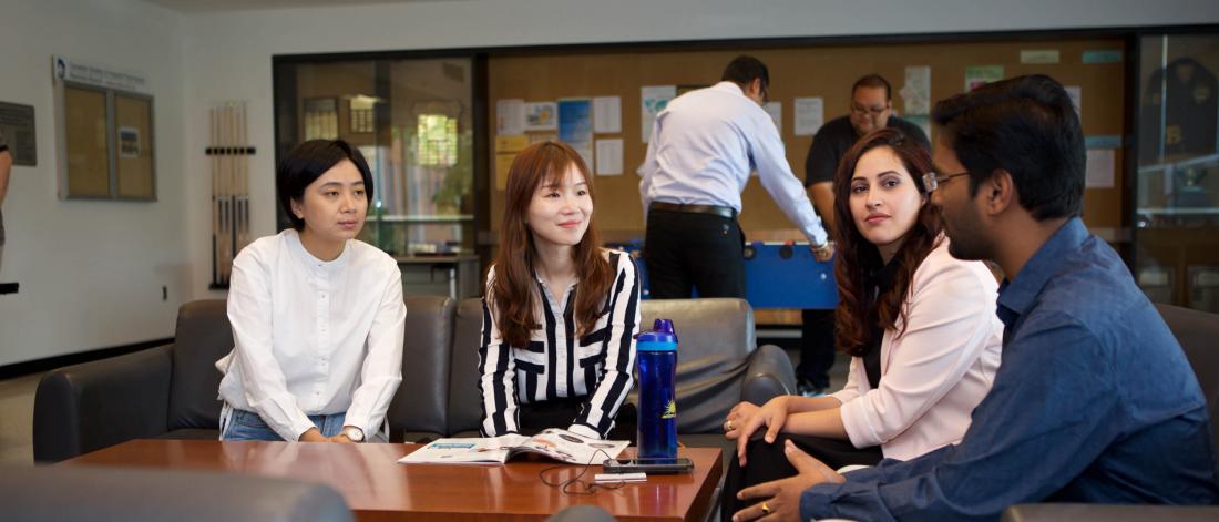Several pharmacy students sit together and talk in the student lounge.