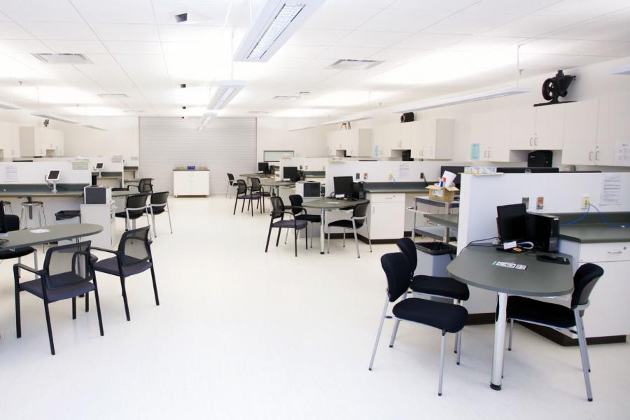 Inside the Pharmaceutical Care lab with rows of desks and cupboard storage.
