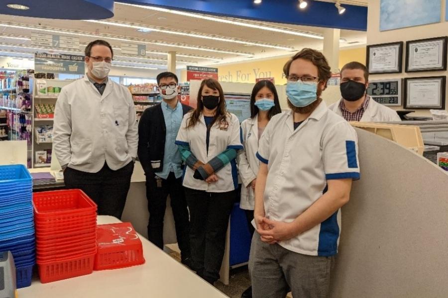 Masked students working in a pharmacy.