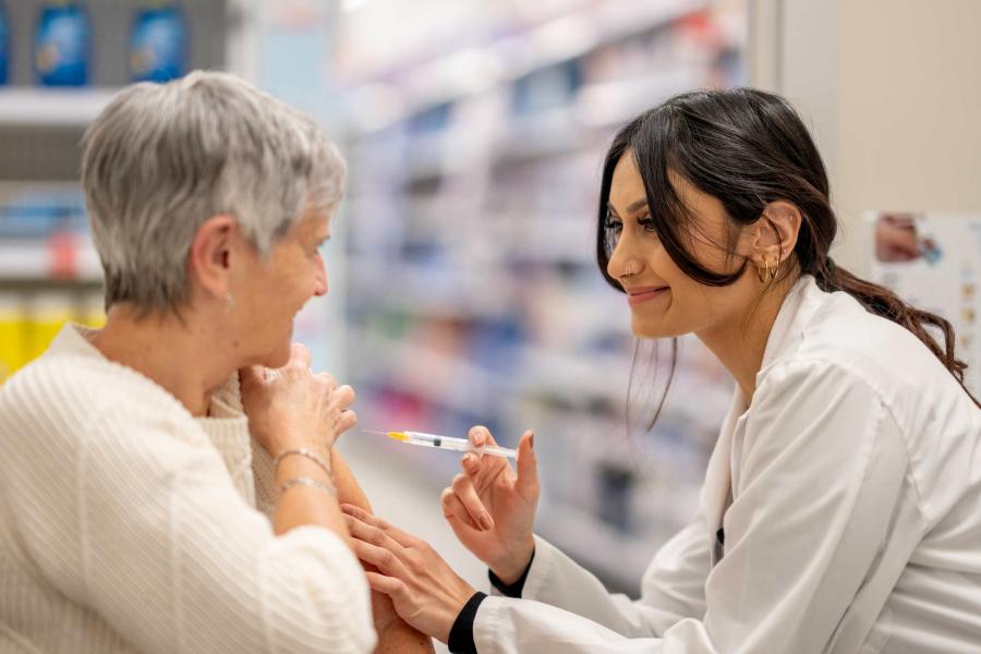 A pharmacist is administering a flu shot on a patient.