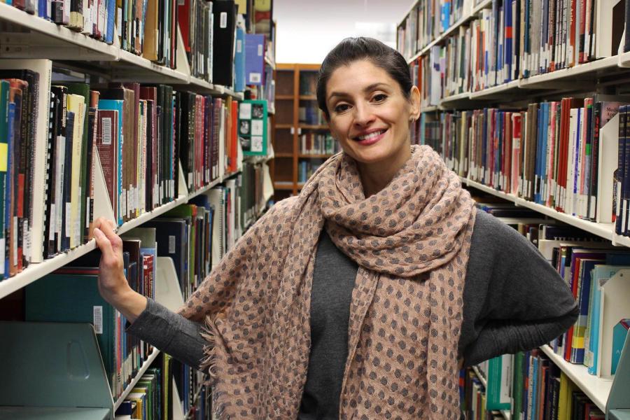 Student poses in Bannatyne library stacks