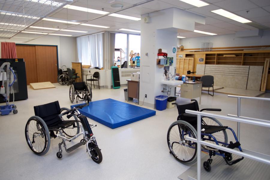 An inside look at the College of Rehabilitation Sciences EPIC lab which is brightly lit with large windows, various wheelchairs and some floor mats are in the room.