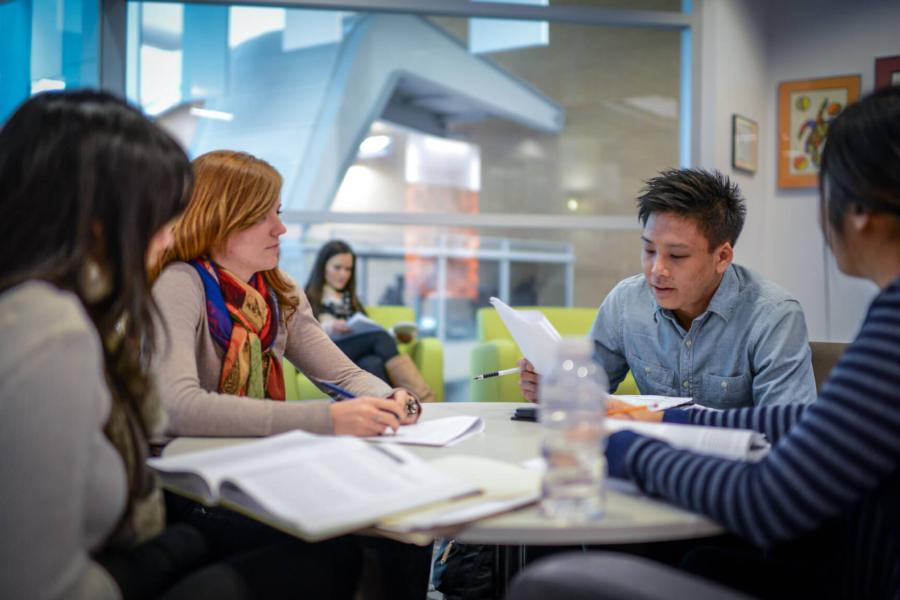 A group of 4 College of Rehabilitation Sciences students sit together at a table studying.