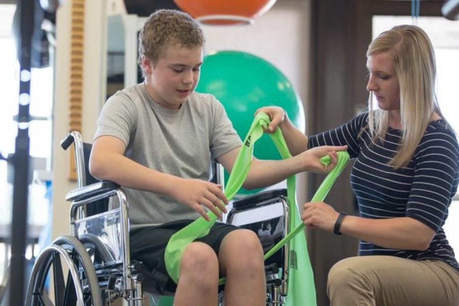Health-care professional assisting patient with a wheelchair