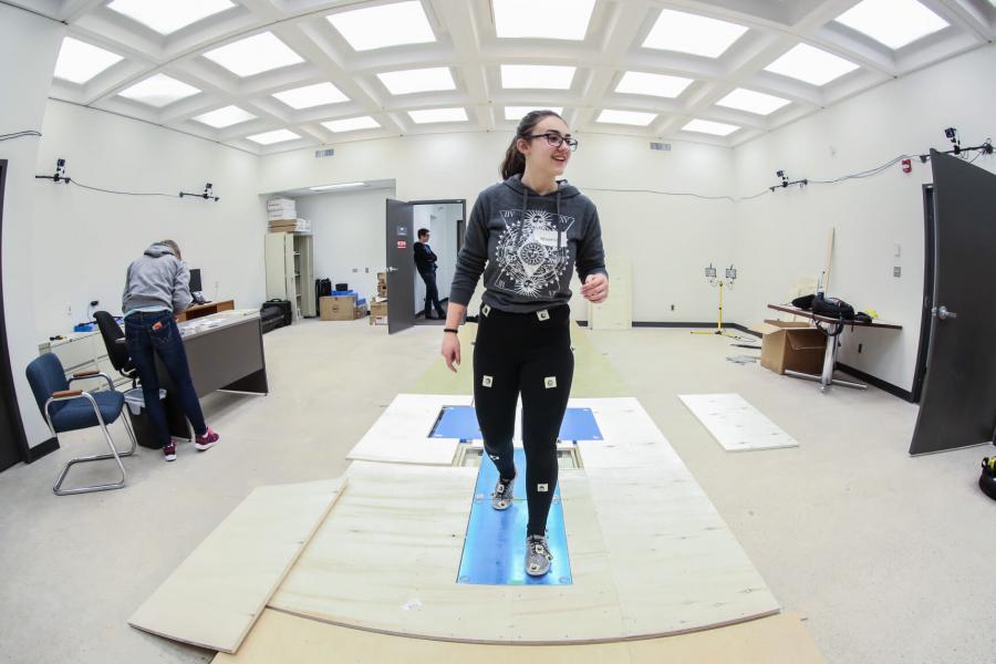 A SET day participant wears sensors and walks along a specialized floor. 