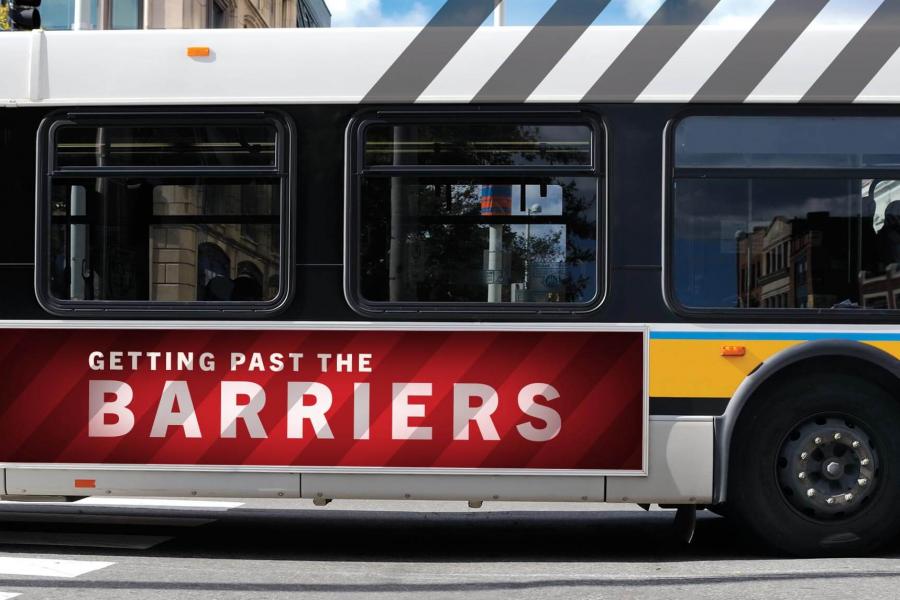 A public transit bus with an advertisement on the side that says 'Getting past the barriers' on it.