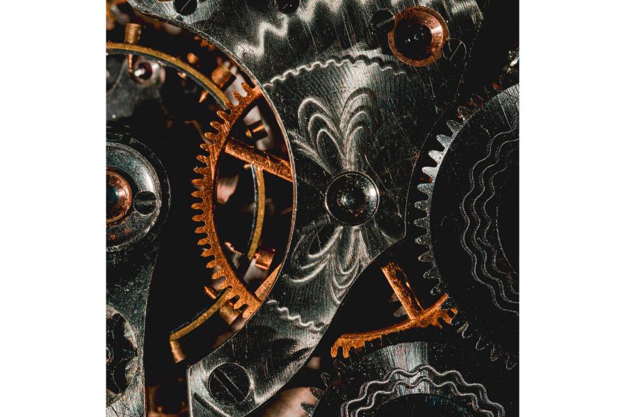 A close up of the inner workings of large circular gears all working together in tandem.