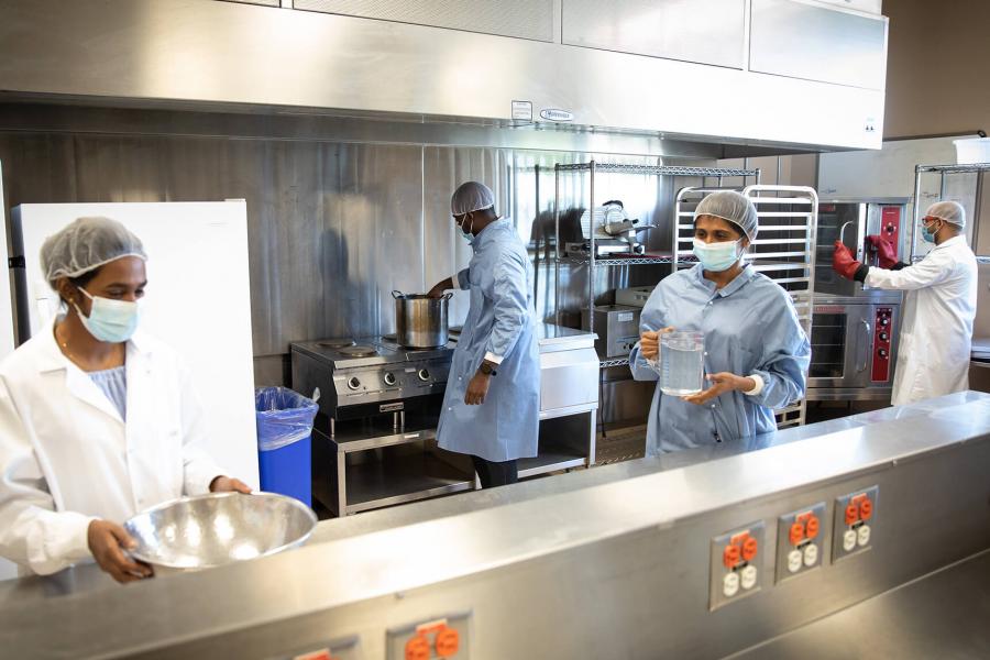 Technicians prepare food in the commercial kitchen.
