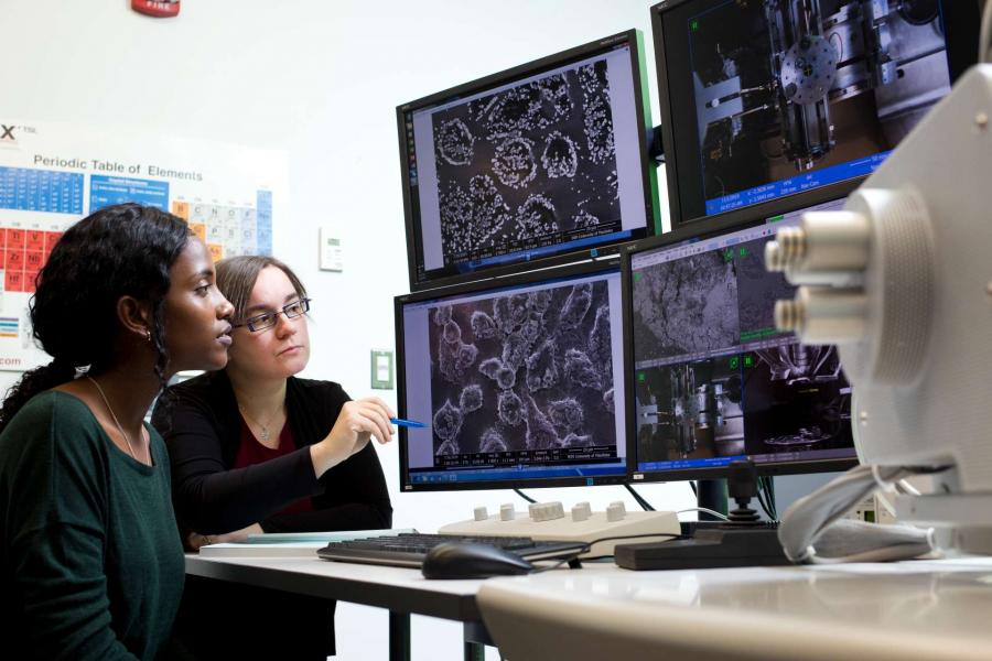 Research scientist and student looking at cell imaging on computer.
