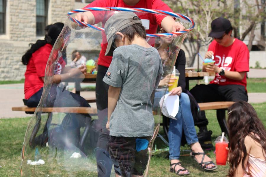 A kid goes through a bubble hoop at Science Rendezvous.