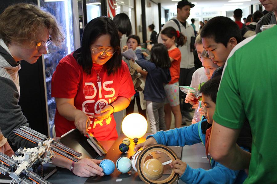 Volunteers interacting with students astronomy booth at Science Rendezvous.