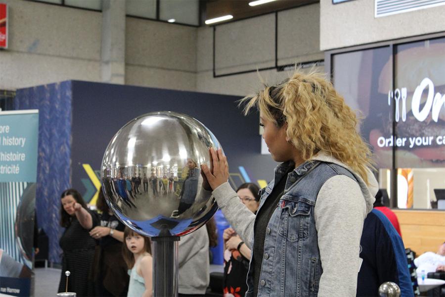 Electric charge on a person's hair at science booths at Science Rendezvous.