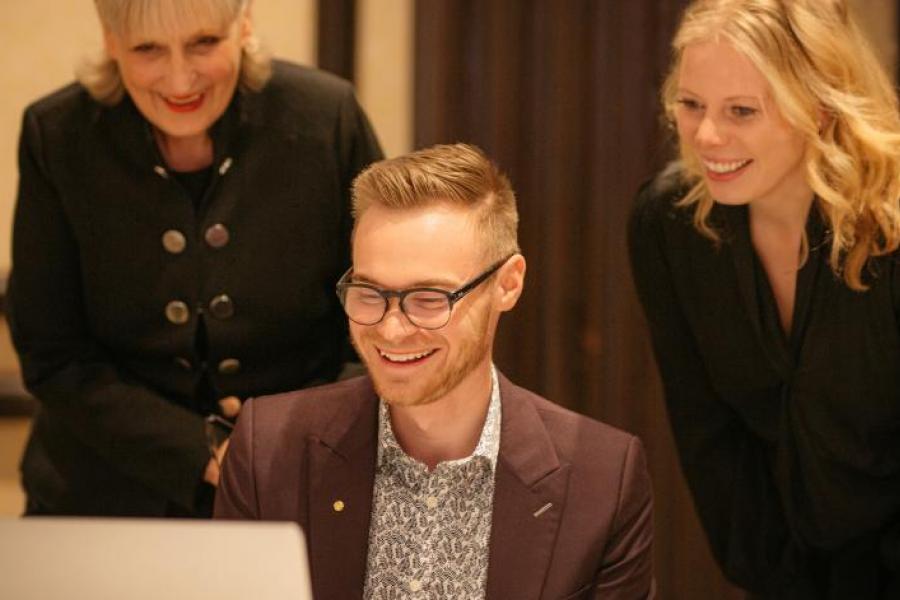Three people looking at a laptop at the Stu Clarke Centre