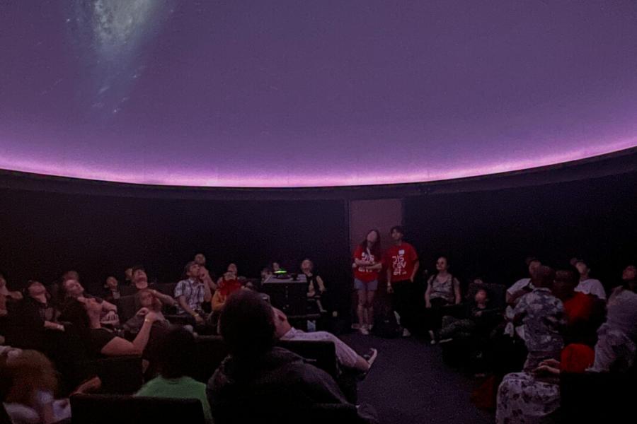 Planetarium show with people and volunteers present.