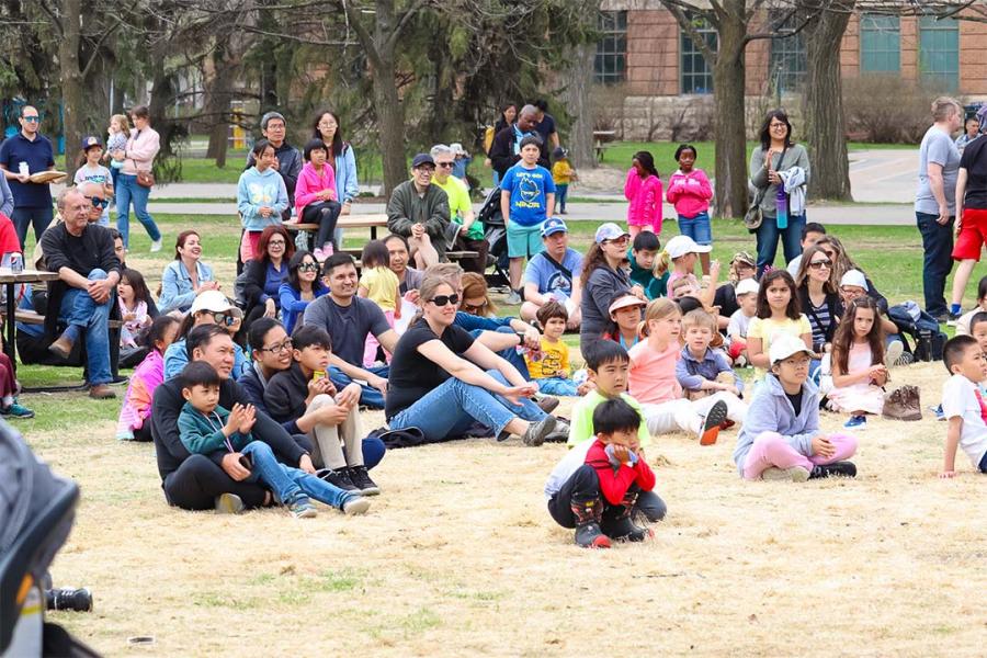 Kids and parents sitting on the ground at The Quad at UM.