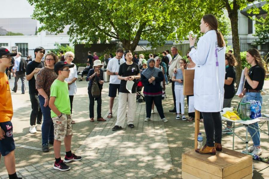 a scientist standing in front of a crowd discussing science