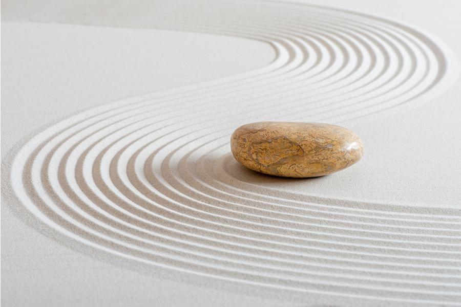 A light brown stone on white sand.