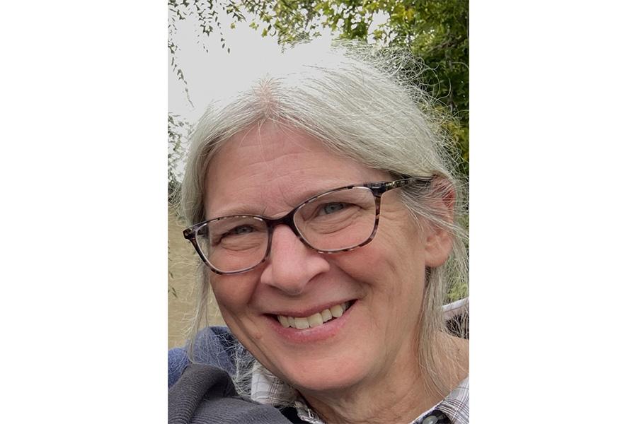 Deborah Court wearing an eyeglass and smiling at the camera.
