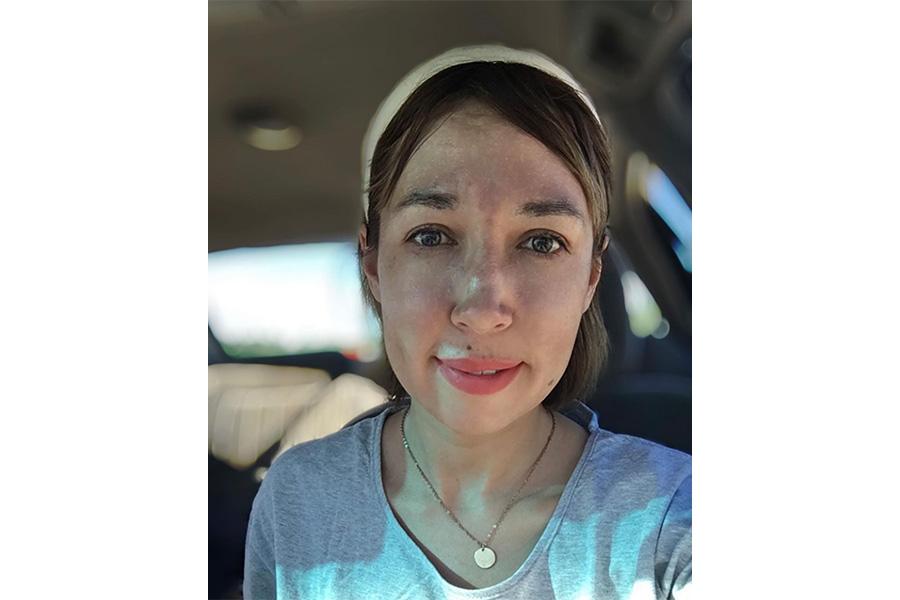 Lilia Shamova wearing a white headband and smiling at the camera.