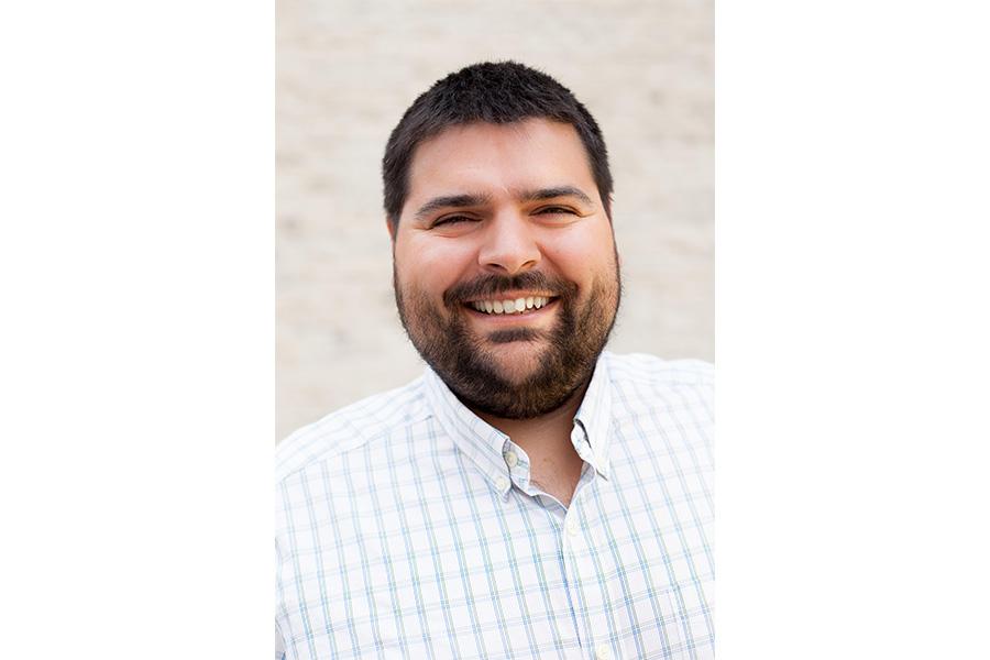 Joey Lussier wearing a button down shirt and smiling at the camera.