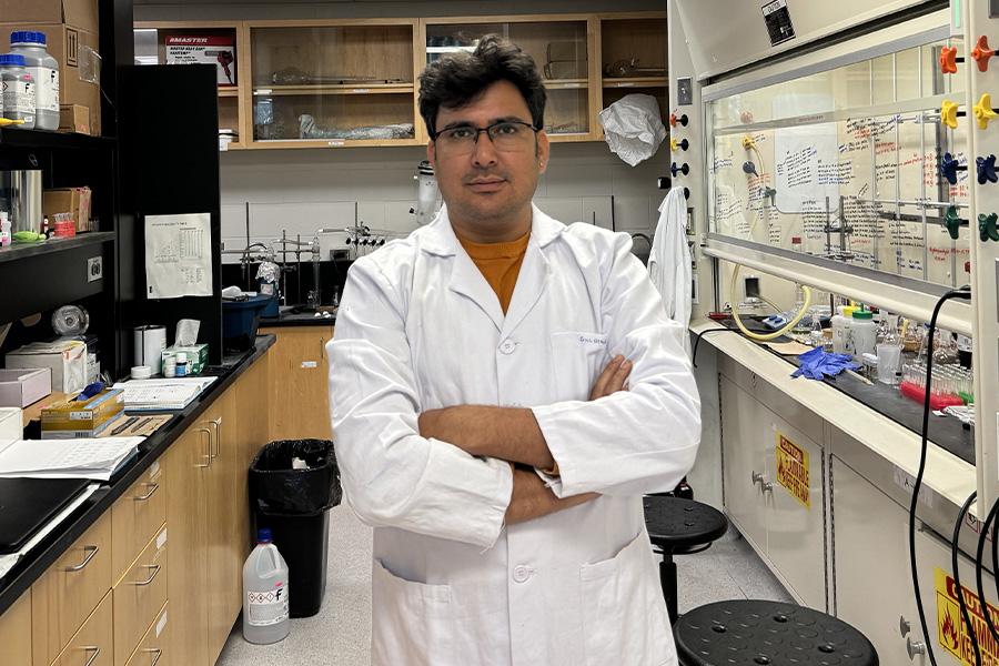 Gulshan Kumar wearing a lab coat and smiling at the camera.