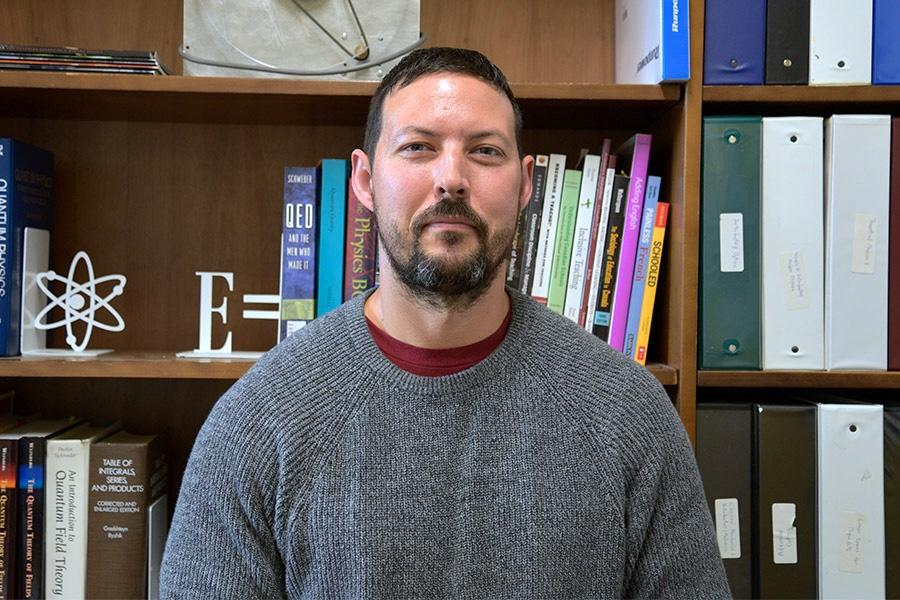 Kyle Shiells wearing a gray sweater and smiling at the camera.