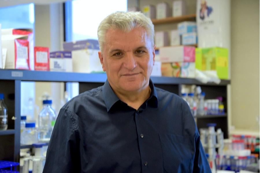 Ned wearing a blue longsleeves smiling at the camera.