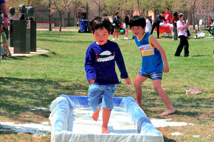 Two kids having fun at the oobleck run and smiling.