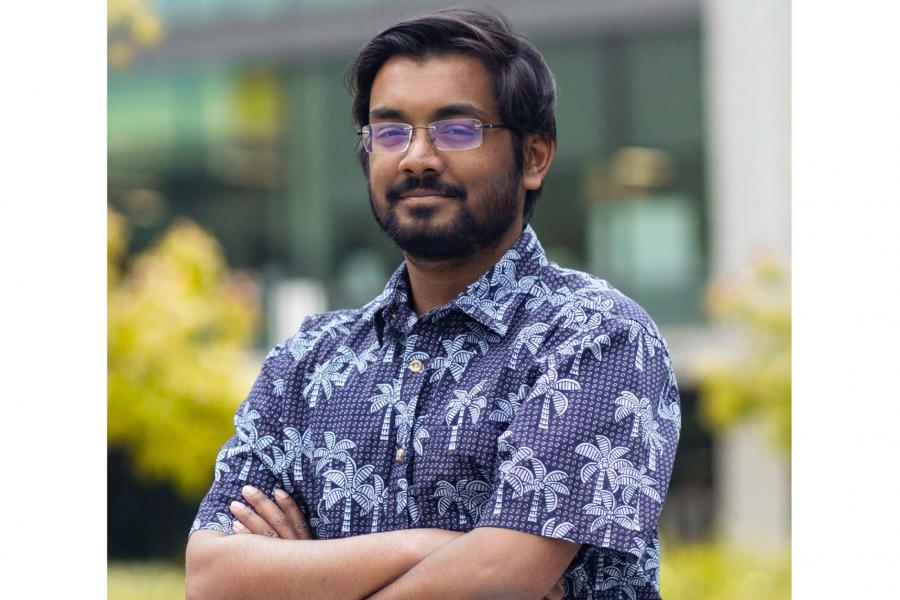 Jay Gupta wearing a printed button down shirt and eyeglass smiling at the camera.