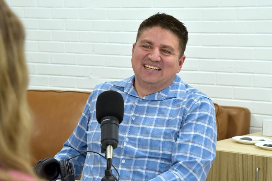 Miguel Uyaguari-Diaz wearing a checkered blue and white long sleeves smiling.