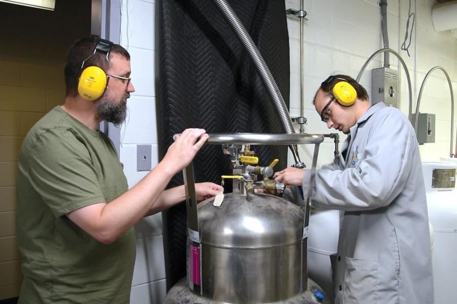 Tim Vos and Michael Opyr working inside the Helium recycling room.