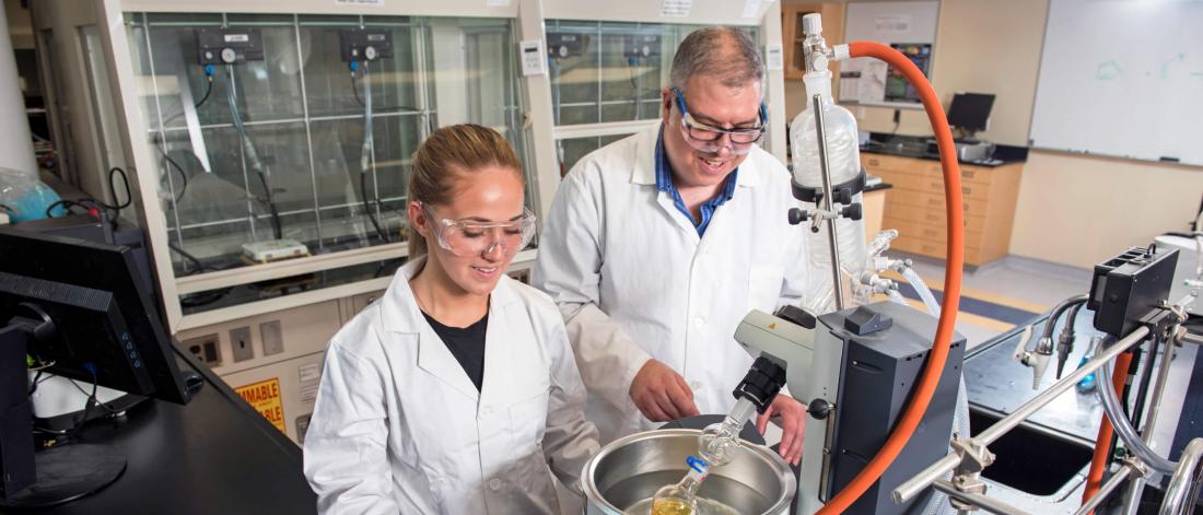 Student and former scholarship recipient Harley Bray works in a lab with an instructor.