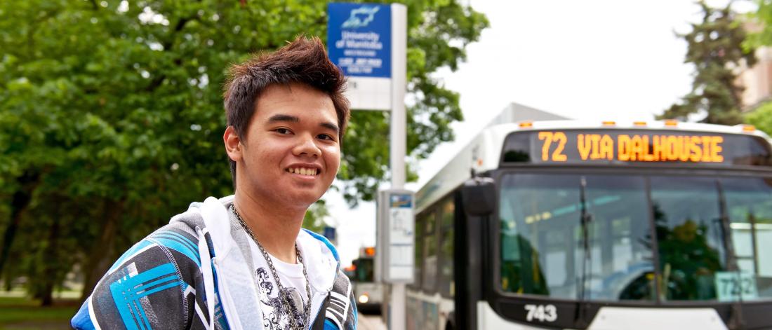 A University of Manitoba student waits at the bus stop for a bus.