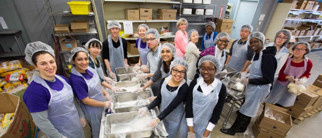 A large group of students sort flour into bags at Winnipeg Harvest. 