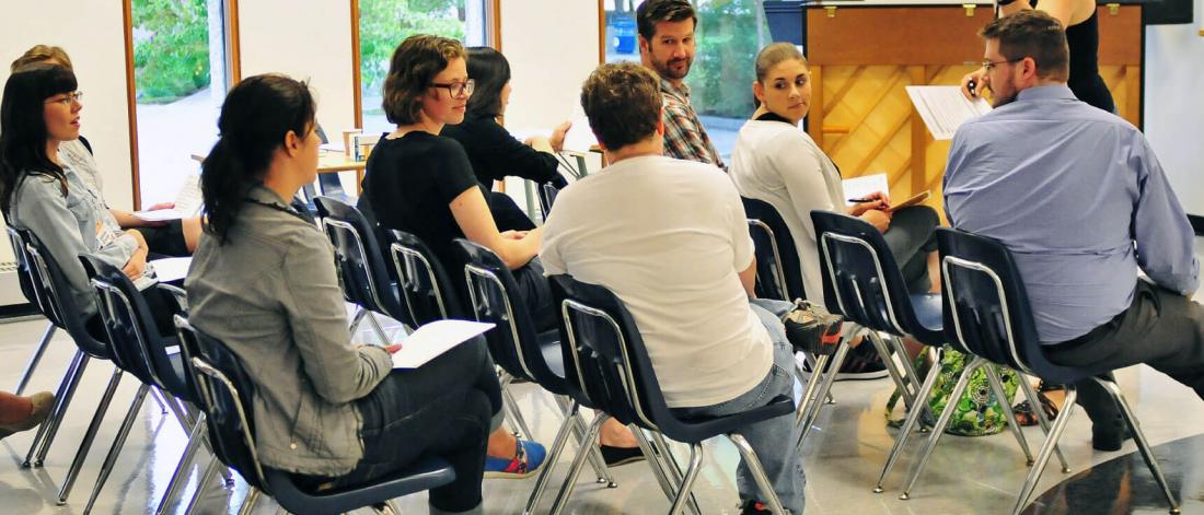 A classroom of people engaging in a conversation with each other.