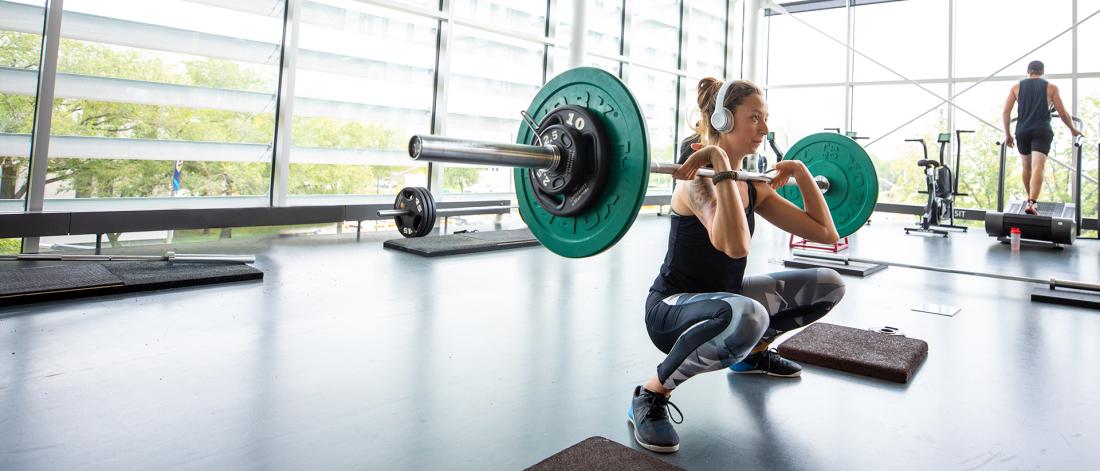 a person doing a barbell front squat at the active living centre