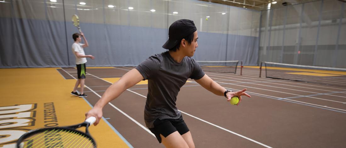 Student playing tennis