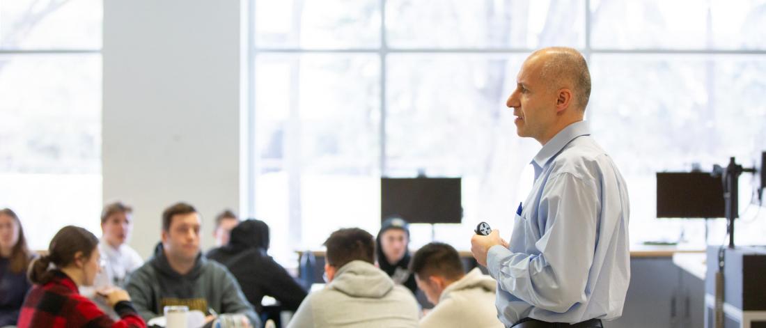 A faculty member instructs a classroom of students.