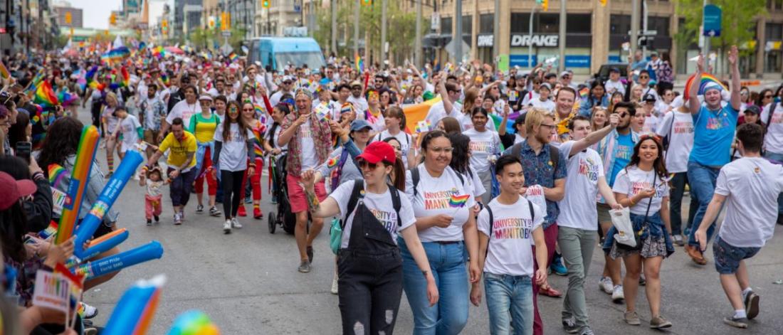 People marching down the street in the Pride Parade.